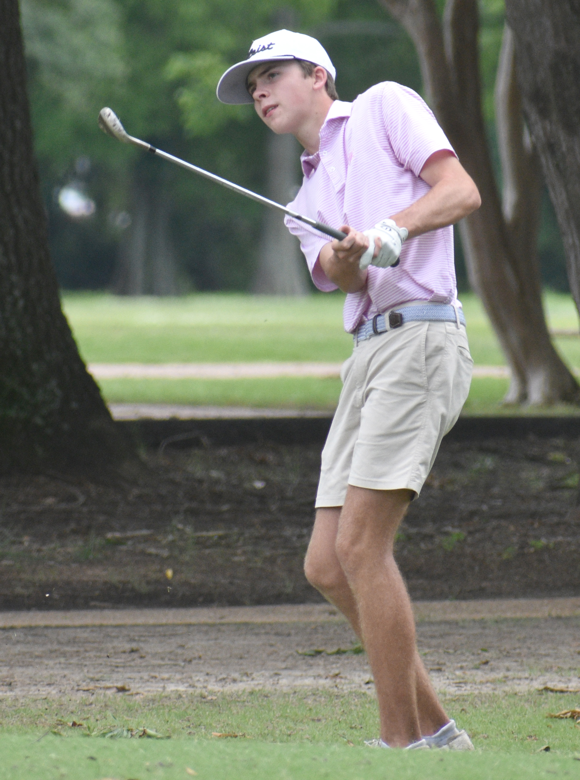 Nickels, left, and Williamson stand with their trophies on Wednesday after the conclusion of the Greenwood Junior Invitational. Right photo: Nickels chips onto the green of the No. 18 hole during golf action at the Greenwood Country Club on Wednesday.  