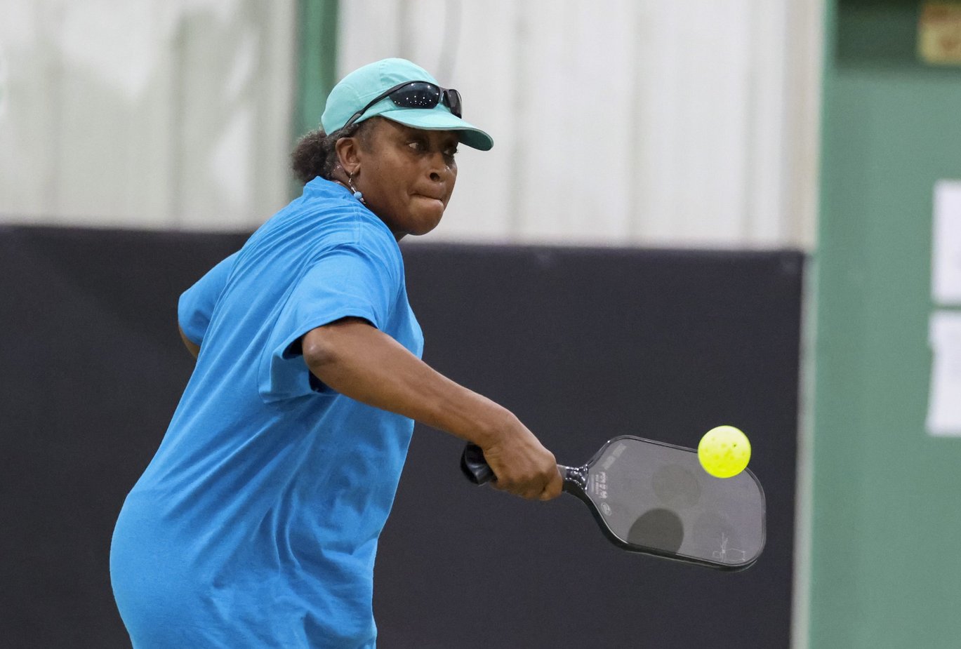 Denise Wiley hits the pickleball during a doubles match.
