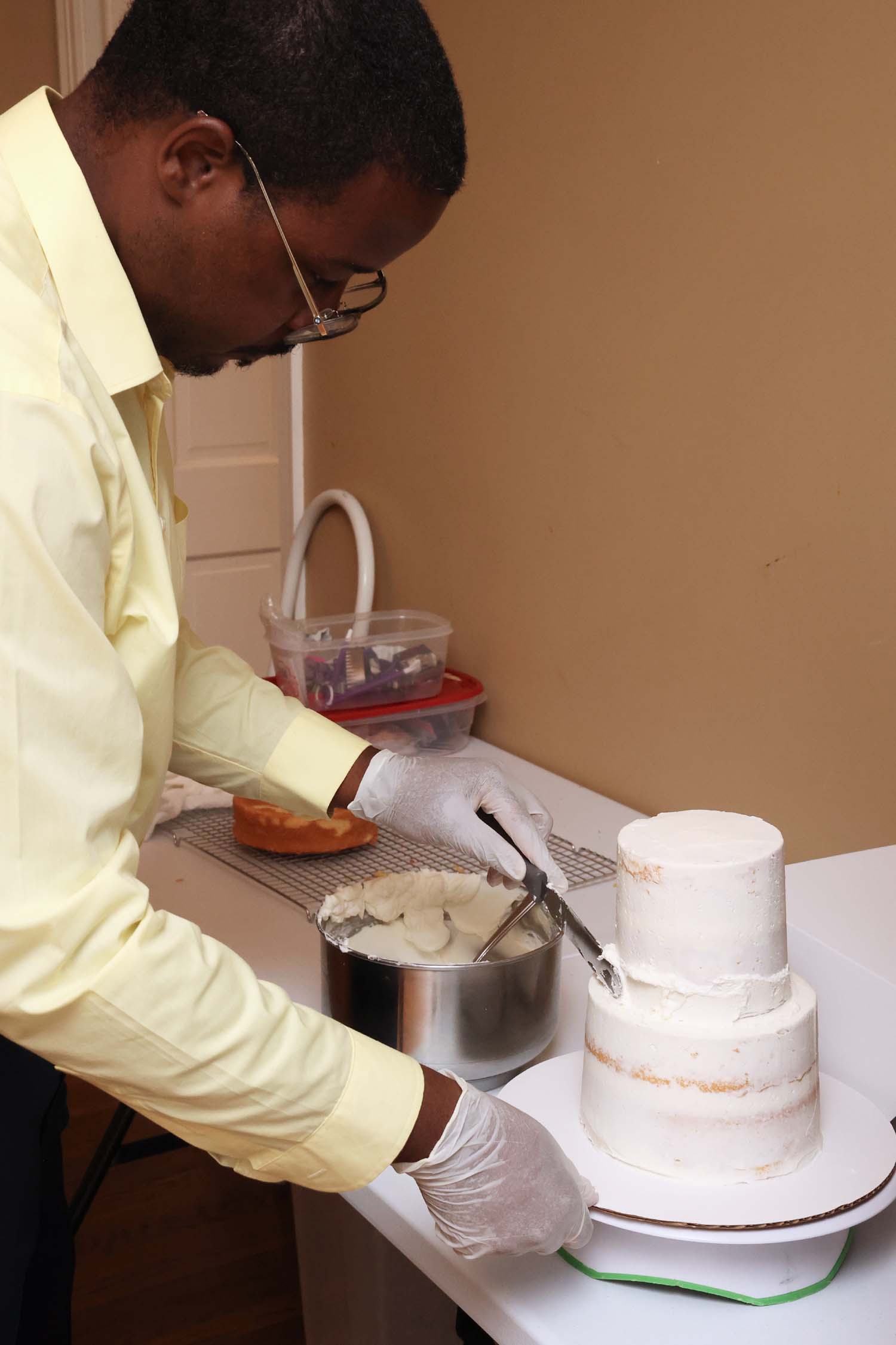 Nevels smooths icing over a two-tier cake. He says he loves to construct cakes, and he wants them to be both flavorful and visually interesting.