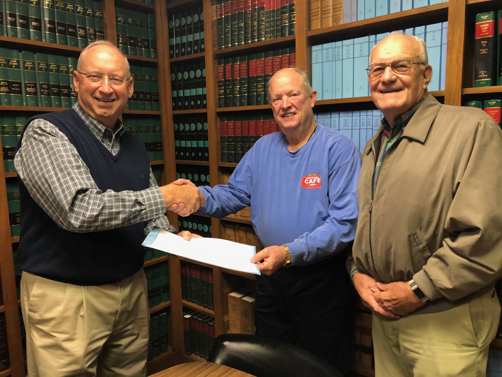 Jim Phillips, president of the Delta Cross nonprofit, celebrates the signing of the deed to receive a 1.33-acre plot of property from the Pillow family in 2019 to erect the Delta Cross. On the right are Dale Pillow and Walter Pillow Sr.