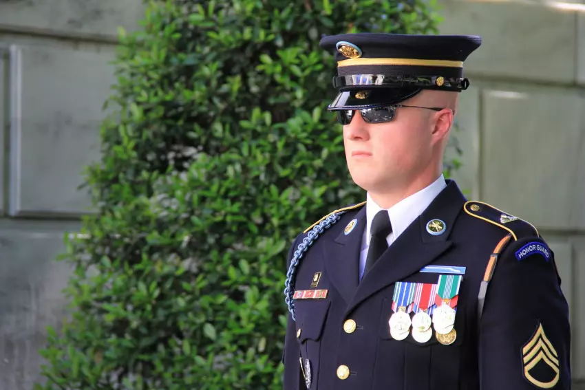 A soldier dressed in formal attire, standing guard outside a building.