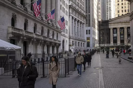 People walk past the New York Stock Exchange on March. 21, 2024. World stocks are mixed on Monday, May 13, 2024, after Wall Street coasted to the close of another winning week. U.S. futures and oil prices were higher. (AP Photo/Yuki Iwamura, File)