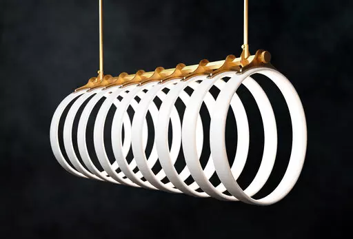 This product image shows Ted Bradley’s Samsara light fixture, made of porcelain and metal, inspired by the arching ribs of a whale skeleton bleached in the sun. (Ted Bradley Studio via AP)