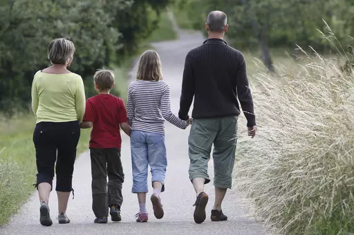 FILE -- This June 14, 2008 file photo shows a family walking through the fields in the village of Gaiberg, near Heidelberg, southwestern Germany. Germany’s justice minister has launched plans to relax the country’s strict restrictions on family names — for example, allowing couples to take double-barreled surnames and pass them on to their children. (AP Photo/Daniel Roland, file)
