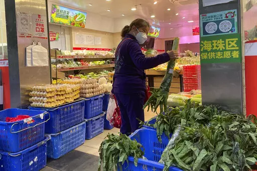 A woman shops in a reopened grocery store in the district of Haizhu as pandemic restrictions are eased in southern China's Guangzhou province, Thursday, Dec. 1, 2022. More Chinese cities eased some anti-virus restrictions as police patrolled their streets to head off protests Thursday while the ruling Communist Party prepared for the high-profile funeral of late leader Jiang Zemin. (AP Photo)