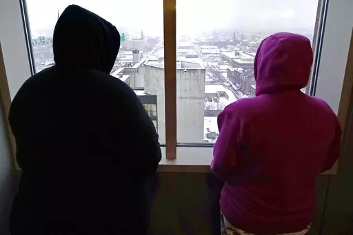 Two women, who allege abuse as minors by the ex-operations chief at New Hampshire's youth detention center, stand in their lawyer's office Thursday, Jan. 12, 2023, in Manchester, N.H. Twenty men and women say they were physically or sexually assaulted as children at New Hampshire's youth detention center by a man who went on to become the facility's chief of operations and later served on a committee advising the state on juvenile justice issues. (AP Photo/Charles Krupa)