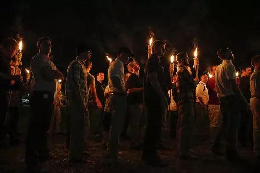 Multiple white nationalist groups march with torches through the University of Virginia campus on Aug. 11, 2017, in Charlottesville, Va. Nearly six years after a large gathering of white nationalists in Charlottesville erupted in violent clashes with counter protesters, a grand jury in Virginia has indicted multiple people on felony charges for carrying flaming torches with the intent to intimidate. (Mykal McEldowney/The Indianapolis Star via AP, File)