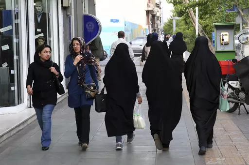 Iranian women make their way along a sidewalk in downtown Tehran, Iran, Tuesday, April 26, 2016. Iranian police have announced a new campaign to force women to wear the Islamic headscarf. Morality police returned to the streets on Sunday, 10 months after the death of a woman in their custody sparked nationwide protests. (AP Photo/Vahid Salemi, File)