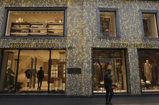 A man walks past a shop in Monte Napoleone street in Milan, Italy, Thursday, Dec. 12, 2024. (AP Photo/Antonio Calanni)
