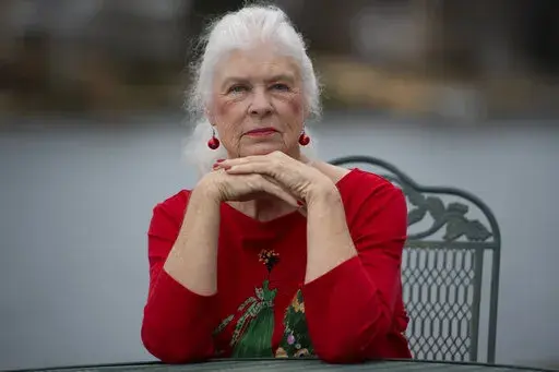 Wanda Olson poses for a photo, Friday, Dec. 17, 2021, in Villa Rica, Ga. When Olson’s son-in-law died in March after contracting COVID-19, she and her daughter had to grapple with more than just their sudden grief. They had to come up with money for a cremation. Even without a funeral, the bill came to nearly $2,000, a hefty sum that Olson initially covered. (AP Photo/Mike Stewart)
