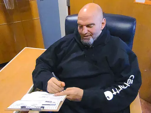 In this photo provided by campaign staffer Bobby Maggio, Pennsylvania Lt. Governor and Democratic Party candidate for a U.S. Senate John Fetterman fills out his emergency absentee ballot for the Pennsylvania primary election in Penn Medicine Lancaster General Hospital in Lancaster, Pa, on Election Day, Tuesday, May, 17, 2022. Fetterman remained in the hospital after suffering a stroke right before the weekend. (Bobby Maggio via AP)