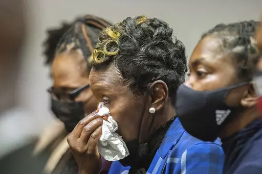 Ahmaud Arbery's mother Wanda Cooper-Jones, center, reacts as Superior Court Judge Timothy Walmsley sentences Greg McMichael, his son, Travis McMichael, and a neighbor, William "Roddie" Bryan in the Glynn County Courthouse, Friday, Jan. 7, 2022, in Brunswick, Ga. The three white men who chased and killed Ahmaud Arbery were sentenced Friday to life in prison, with a judge denying any chance of parole for the father and son who armed themselves and initiated the deadly pursuit of Arbery, a 25-year-