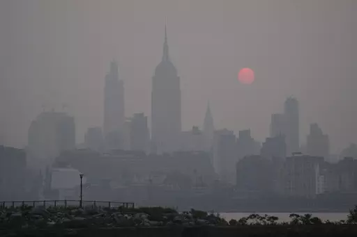 The sun rises over a hazy New York City skyline as seen from Jersey City, N.J., Wednesday, June 7, 2023. (AP Photo/Seth Wenig)