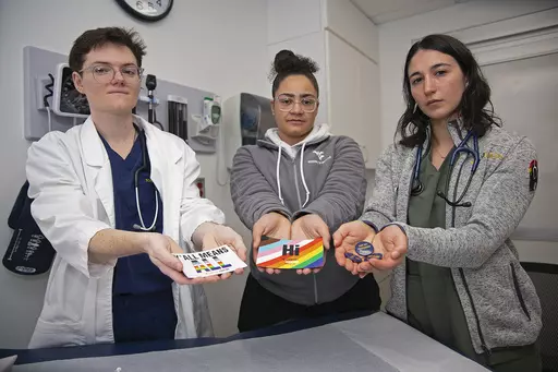 West Virginia University students El Didden, Bri Caison and Lia Farrell hold materials from the Rainbow Coats on Wednesday, March 8, 2023, in Morgantown, W.Va. (AP Photo/Kathleen Batten)