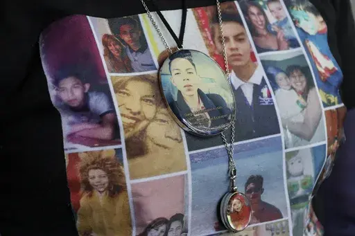 Photos of Veronica Rosas and her son Diego decorate Veronica's shirt and necklaces, as she poses for a portrait at her home in Ecatepec, Mexico, Friday, Aug. 2, 2024. Rosas' son went missing when he was 16 years old on Sept. 4, 2015. (AP Photo/Ginnette Riquelme)