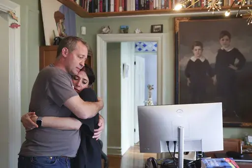 Jake Heinrichs hugs his wife, Rachel Chavkin, after speaking about early-stage Alzheimer's disease while inside their home in New York, on Wednesday, March 12, 2025. (AP Photo/Heather Khalifa)
