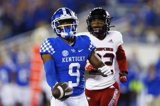 Kentucky wide receiver Tayvion Robinson (9) runs the ball into the end zone for a touchdown while being chased by Northern Illinois cornerback Cyrus McGarrell (22) during the second half of an NCAA college football game in Lexington, Ky., Saturday, Sept. 24, 2022. (AP Photo/Michael Clubb)