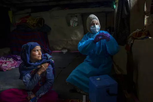 Masrat Farid, a healthcare worker, prepares to administer a dose of Covishield vaccine to Rubia Begum inside a hut during a COVID-19 vaccination drive in Gagangeer, northeast of Srinagar, Indian controlled Kashmir on June 22, 2021. Farid has traveled long distances to vaccinate mostly shepherds and nomadic herders in the remote meadows of the Himalayan region of Indian-controlled Kashmir. (AP Photo/Dar Yasin)