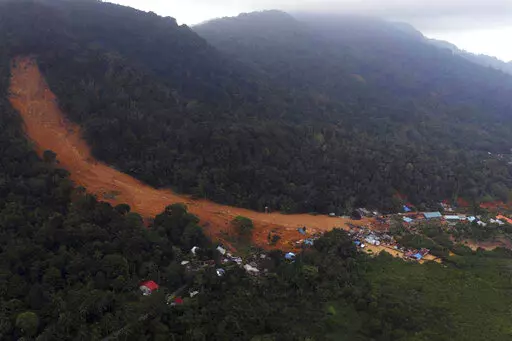 This aerial photo released by Indonesia's National Disaster Management Agency (BNPB) on Wednesday, March 8, 2023, shows a village affected by landslide on Serasan Island, Natuna regency, Indonesia. Rescuers in the remote Indonesian islands are searching for people who are believed to be buried in their houses by landslides that tore through villages after torrential rains and killed a number of people. (BNPB via AP)