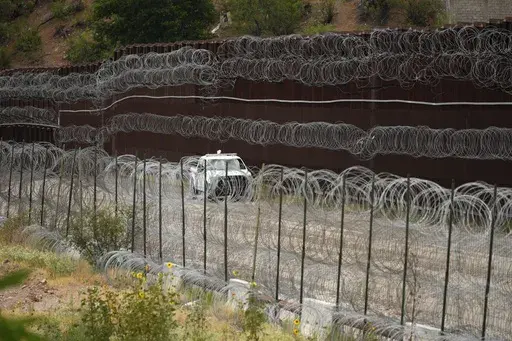A vehicle drives along the U.S. side of the US-Mexico border wall in Nogales, Ariz., June 25, 2024. The Biden administration is making asylum restrictions at the southern border even tougher. The changes come in the middle of an election campaign where border security is a key concern for voters, and the administration is increasingly eager to show voters it's taking a hard stance. (AP Photo/Jae C. Hong, Pool, File)