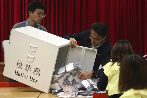 Election workers empty a ballot box to count votes for a district council election at a polling station in Hong Kong, Nov. 24, 2019. Hong Kong's leader on Tuesday, May 2, 2023, stepped up a campaign to shut down democratic challenges by unveiling plans to eliminate most directly elected seats on local district councils, the last major political representative bodies mostly chosen by the public. (AP Photo/Ng Han Guan, File)