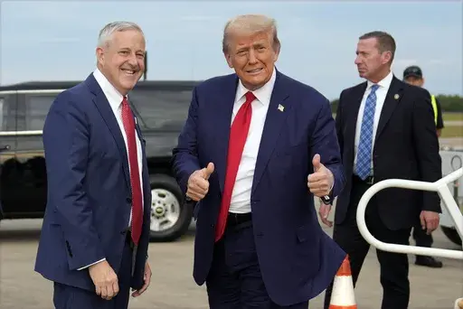 Republican presidential nominee former President Donald Trump stands with Republican National Committee chair Michael Whatley as he arrives at Fayetteville Regional Airport to attend a town hall, Friday, Oct. 4, 2024, in Fayetteville, N.C. (AP Photo/Evan Vucci)
