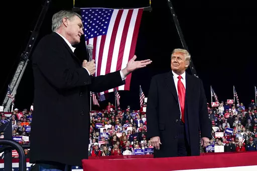 Former Sen. David Perdue of Georgia, speaks as President Donald Trump looks on, at a campaign rally at Valdosta Regional Airport, Dec. 5, 2020, in Valdosta, Ga. Perdue is building his campaign around Donald Trump and veering to the right as he tries to unseat Republican Gov. Brian Kemp in a May 24 GOP primary. (AP Photo/Evan Vucci, File)