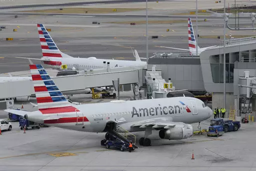 American Airlines planes sit on the tarmac at Terminal B at LaGuardia Airport, Jan. 11, 2023, in New York. American Airlines is raising bag fees and pushing customers to buy tickets directly from the airline if they want to earn frequent-flyer points. American said Tuesday, Feb. 20, 2024, that checking a bag on domestic flights will rise from $30 now to $35 online, and it'll be $40 if purchased at the airport. (AP Photo/Seth Wenig, File)