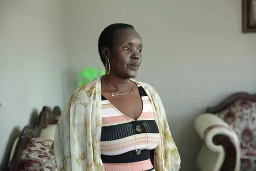 Achut Deng, a refugee from South Sudan, poses in her home in Sioux Falls, S.D., on Sept. 17, 2022, before the release of her memoir, “Don’t Look Back.” Deng shared her experience of being sickened with COVID-19 alongside hundreds of her coworkers at a pork processing plant. She shares her story of fleeing massacres and surviving a refugee story in her book. (AP Photo/Stephen Groves)