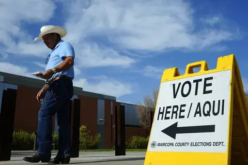 A voter walks to a voting precinct prior to casting his ballot in the state's primary election, Tuesday, July 30, 2024, in El Mirage, Ariz. (AP Photo/Ross D. Franklin, File)