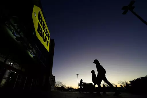 Shoppers are silhouetted against the sky as they arrives for a sale at a Best Buy store Friday, Nov. 25, 2022, in Overland Park, Kan. On Friday the Commerce Department issues its November report on consumer spending. The report contains a measure of inflation that is closely watched by the Federal Reserve, which has aggressively tried to corral inflation this year by raising its key lending rate seven times. (AP Photo/Charlie Riedel, File)