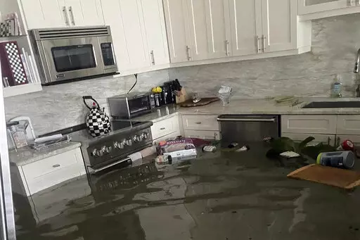 This image provided courtesy of Heather Donlan and posted on social media, shows flooding from Hurricane Ian in her father's home in Naples, Fla. Donlan said her social media post crowdsourced the person she holds responsible for saving her father's life as flooding inundated the 87-year-old's home.  (Courtesy of Heather Donlan via AP)