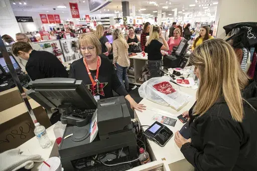 Terri Ross, left, checks out a customer at a store in the Huntington Mall in Barboursville, W.Va., on Nov. 25, 2022. (Sholten Singer/The Herald-Dispatch via AP, File)