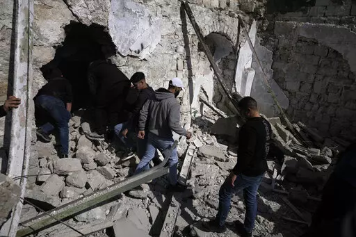 Palestinians inspect the ruins of a militant hideout destroyed during a raid by Israeli forces in the Old City of Nablus in the West Bank, Wednesday, Feb. 22, 2023. Israeli troops moved into the city, setting off fighting that killed several Palestinians, including a 72-year-old man, Palestinian health officials said. The Israeli military gave few details about its operation in the northern city, which is known as a militant stronghold, and the army frequently operates there. (AP Photo/Majdi Moh