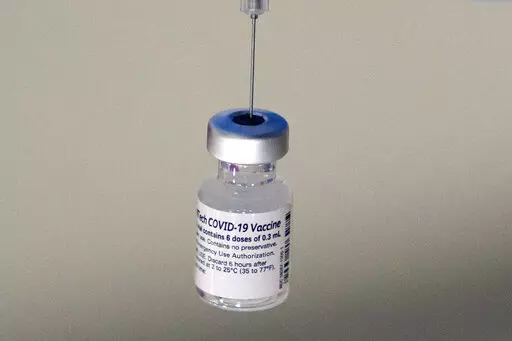 A syringe is placed into a vial of Pfizer-BioNTech vaccination at a COVID-19 clinic in Augusta, Maine, on Tuesday, Dec. 21, 2021. On Thursday, Oct. 20, 2022, Pfizer said it will charge $110 to $130 for a dose of its COVID-19 vaccine once the U.S. government stops buying the shots, but the drugmaker says it expects many people will continue receiving doses for free. (AP Photo/Robert F. Bukaty, File)