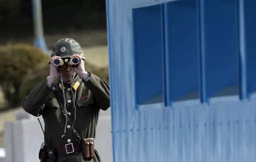 A North Korean soldier looks at the southern side through a pair of binoculars at the border village of the Panmunjom, in the Demilitarized Zone, DMZ, that separates the two Koreas since the Korean War, in Paju, north of Seoul, South Korea, Tuesday, March 19, 2013. A series of low-slung buildings and somber soldiers dot the landscape of the DMZ, the swath of land between North and South Korea where a soldier on a tour crossed into North Korea on Tuesday, July 18, 2023, under circumstances that r