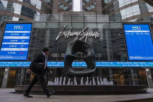 A pedestrian passes by the Hong Kong Stock Exchange electronic screen in Hong Kong on Monday, March 13, 2023. Asian shares mostly fell Monday, shaken by a Wall Street tumble that set off worries the biggest U.S. bank failure in nearly 15 years might have ripple effects around the world. (AP Photo/Louise Delmotte)