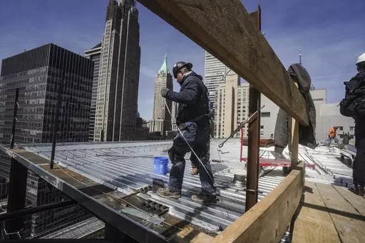 Construction workers install roofing on a high rise in Manhattan's financial district on Tuesday, April 11, 2023, in New York. On Friday, the U.S. government issues the April jobs report. (AP Photo/Bebeto Matthews, File)
