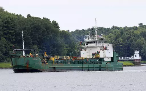 Spectators watch as a dredger works to deepen a shallow channel in the Kennebec River, upstream from the Doubling Point Lighthouse, Aug. 5, 2011, in Arrowsic, Maine. Eleven people were hurt when a walkway collapsed during an annual event that encourages tours of Maine lighthouses. The wooden walkway collapsed at Doubling Point Lighthouse on Saturday, Sept. 9, 2023. (AP Photo/Robert F. Bukaty, file)