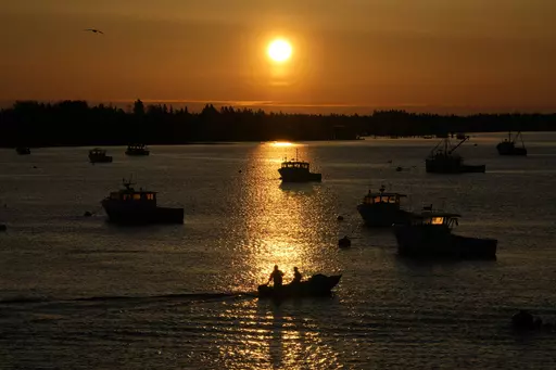 Lobstermen motor out to their moored fishing boat in Jonesport, Maine, Thursday, April 28, 2023. The fishing industry is a major employer in the rural area where a local family wants to build the world's tallest flagpole. Situated at the nation’s eastern tip, Maine’s Down East region is the place where the sunlight first kisses U.S. soil each day. (AP Photo/Robert F. Bukaty)