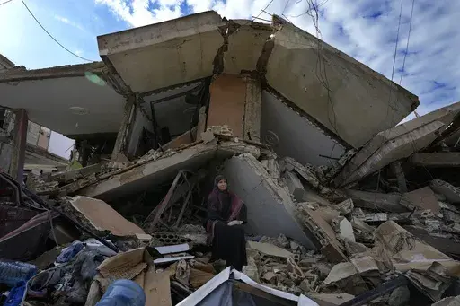 Mariam Kourani, 56, sits on the rubble of her destroyed house after she returned with her family to Hanouiyeh village, southern Lebanon, Thursday, Nov. 28, 2024 following a ceasefire between Israel and Hezbollah that went into effect on Wednesday.(AP Photo/Hussein Malla)