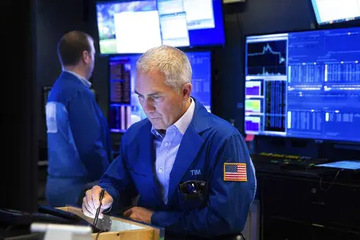 In this photo provided by the New York Stock Exchange, trader Timothy Nick works in his booth on the trading floor, Friday, Feb. 18, 2022. Stocks fell in afternoon trading on Wall Street Friday as major indexes head for their second weekly loss in a row after another bout of turbulence shook market. (Allie Joseph/New York Stock Exchange via AP)