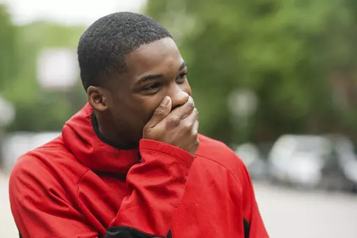 Anthony Perry, 20, reacts after Early Walker, founder of the organization I'm Telling Don't Shoot, surprised him with a free car, Wednesday morning, June 8, 2022, in Chicago. Walker surprised Perry with the car after video of him saving a man from being electrocuted after falling onto the 59th Street red line train tracks went viral earlier in the week. (Pat Nabong/Chicago Sun-Times via AP)