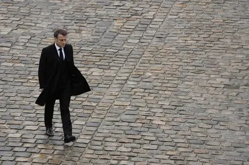 French President Emmanuel Macron walks back during a ceremony at the Invalides monument, Wednesday, Feb.7, 2024. French President Emmanuel Macron's expected political failure in decisive parliamentary elections Sunday may paralyze the country, weaken him abroad and overshadow his legacy, just as France is about to be in the global spotlight as host of the Paris Olympics. (AP Photo/Thibault Camus, File)