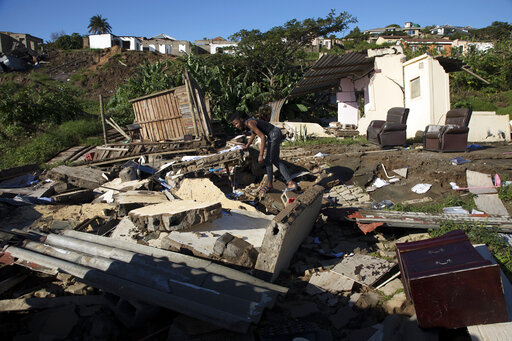 Alwande Ndlovu, stands where a neighbour's house once stood, after heavy rains caused flood damage in Umgababa, near Durban, South Africa, Tuesday, April 19, 2022. Declaring a national state of disaster, South Africa has allocated $67 million to help those hit by floods that have killed at least 443 people in the eastern city of Durban and the surrounding KwaZulu-Natal province. (AP Photo/Str)