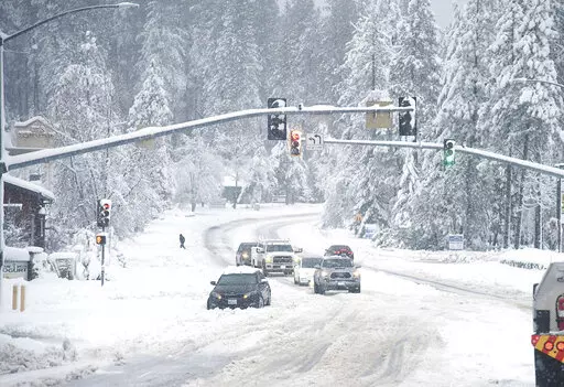 A vehicle is stuck in the snow along Brunswick Road and Sutton Way Monday morning, Dec. 27, 2021, in Grass Valley, Calif. (Elias Funez/The Union via AP)