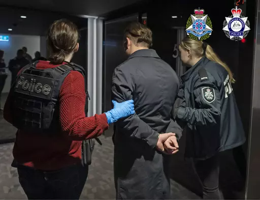 In this photo provided by the Australian Federal Police a man is taken into custody in Melbourne, Wednesday, June 14, 2023. A drug syndicate that tried to smuggle tons of methamphetamine from Canada to Australia and New Zealand by hiding it in shipments of maple syrup and canola oil has been busted, authorities said Thursday, June 15. (Australian Federal Police via AP)