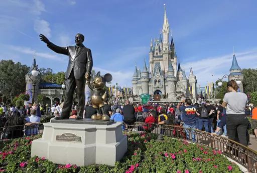 A statue of Walt Disney and Micky Mouse stands in front of the Cinderella Castle at the Magic Kingdom at Walt Disney World in Lake Buena Vista, Fla., Jan. 9, 2019. Tens of thousands of LGBTQ+ people are flocking to Florida's theme parks and hotels to go on thrill rides, dance at all-night parties and lounge poolside in a decades-long tradition known as Gay Days. Even though Gov. Ron DeSantis and Florida lawmakers have championed a slew of anti-LGBTQ laws, that's not stopping organizers from enco