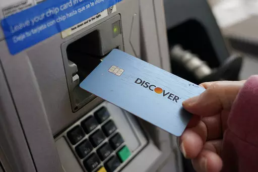A consumer uses a Discover card in Madison, Miss., Thursday, July 1, 2021.  In 2021,  dedicate a financial account to goods, services and activities that bring you joy. Perhaps this fund would cover monthly massages or weekly smoothies, or it could be used to save up for a vacation.  (AP Photo/Rogelio V. Solis)