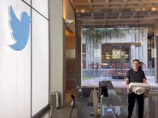 This image from the Twitter page of Elon Musk shows Musk entering Twitter headquarters carrying a sink through the lobby area on Wednesday, Oct. 26, 2022 in San Francisco.  Musk posted a video Wednesday showing him strolling into Twitter headquarters ahead of a Friday deadline to close his $44 billion deal to buy the company.  (Twitter page of Elon Musk via AP)